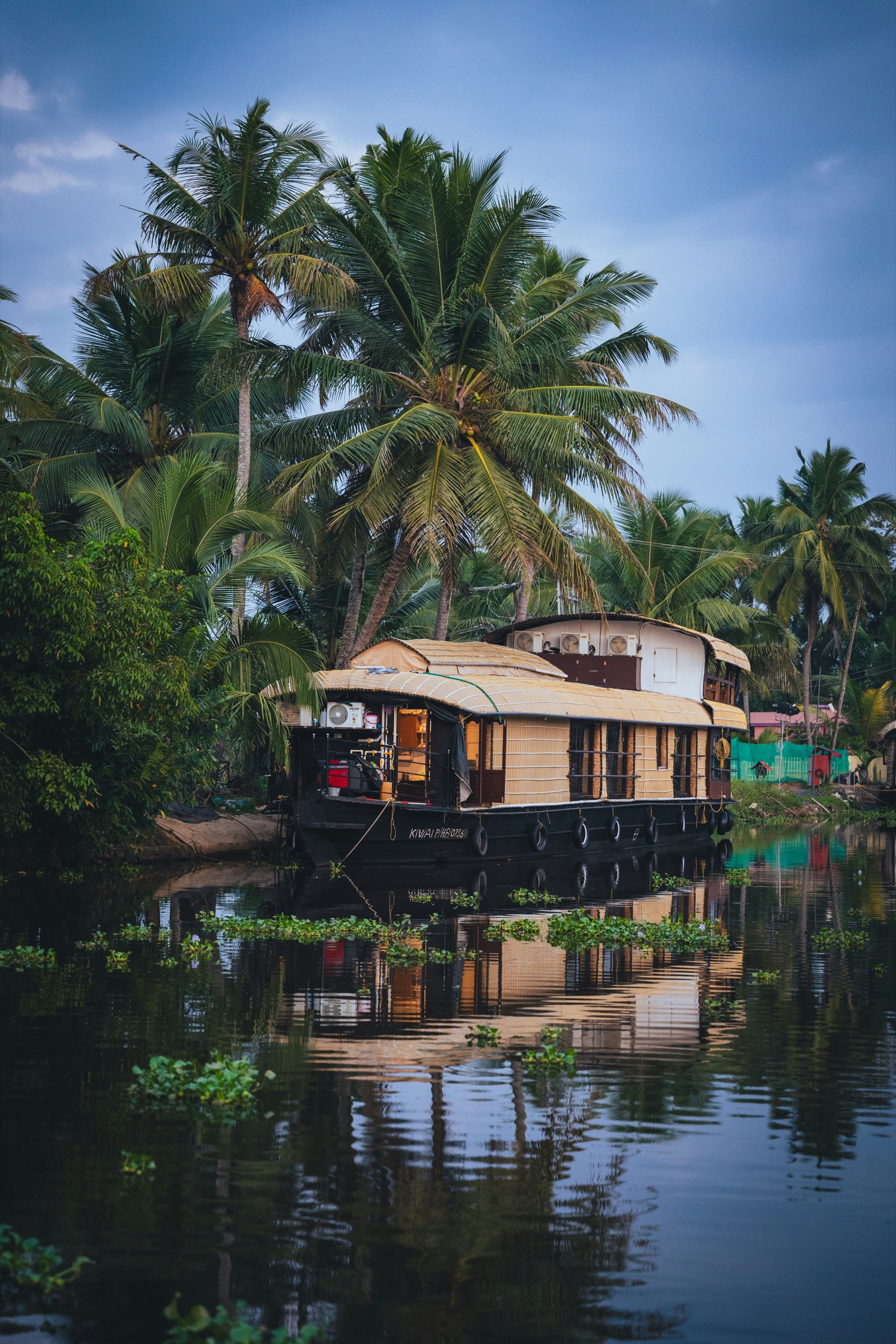 Kerala backwaters at dawn, a traditional houseboat on still water